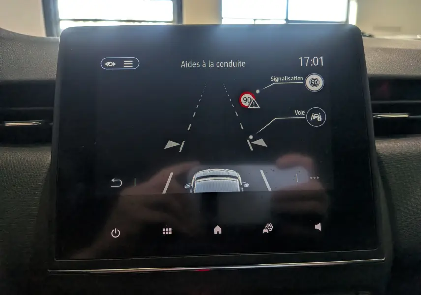 Écran tactile intérieur de la Renault Clio V gris platine montrant l'aide à la conduite avec signalisation et voie active.