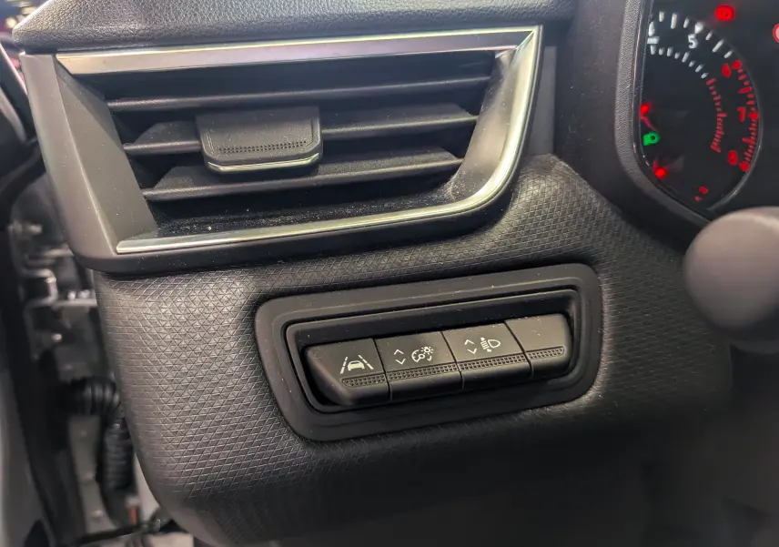 Vue rapprochée du tableau de bord côté gauche de la Renault Clio V gris platine, montrant les commandes d’assistance et réglages lumineux.