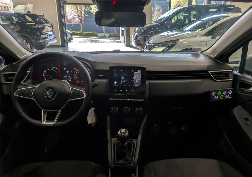 Vue intérieure avant de la Renault Clio V TCe 90 auto-école, tableau de bord noir avec écran tactile central et levier de vitesses manuel.