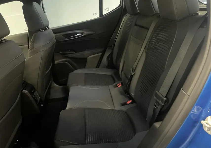 Vue intérieure côté droit sur la banquette arrière noire de l'Alfa Romeo Tonale bleu 2024 avec ceinture de sécurité.