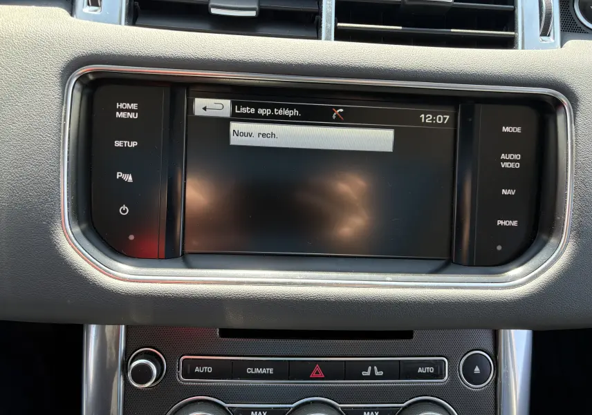 Vue rapprochée de l’écran tactile central et des commandes de climatisation du Range Rover Sport Mark III 2015, intérieur noir.