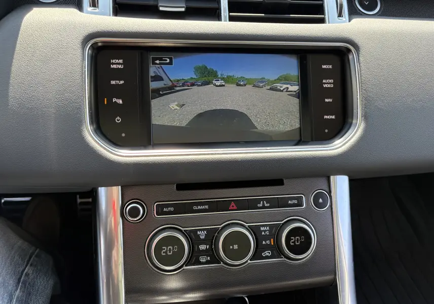 Vue intérieure du tableau de bord du Range Rover Sport 2015, écran de caméra de recul et commandes de climatisation visibles.