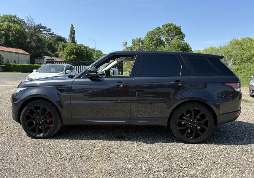 Range Rover Sport 2015 noir en vue de profil côté gauche, avec jantes noires et étriers de frein rouges visibles.