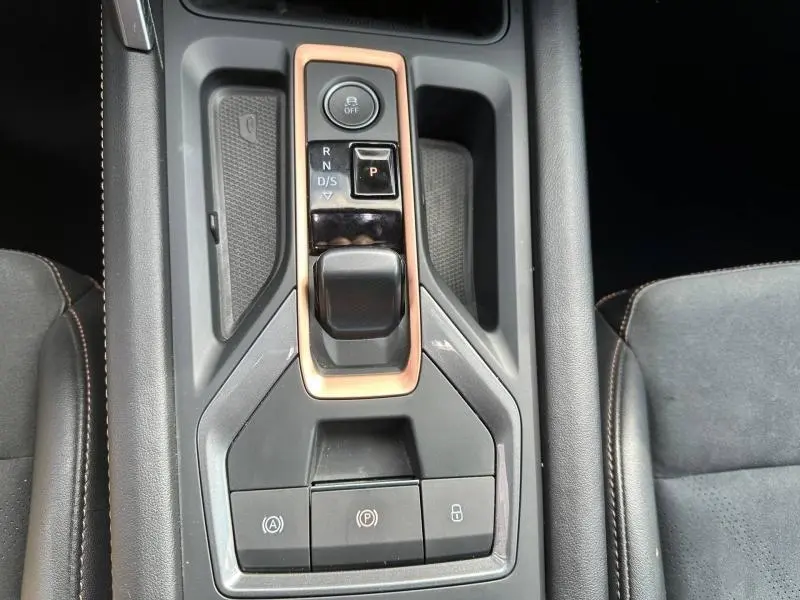 Gros plan sur la console centrale de la CUPRA Formentor gris métallisé, montrant la commande de boîte auto et les boutons de frein et verrouillage.