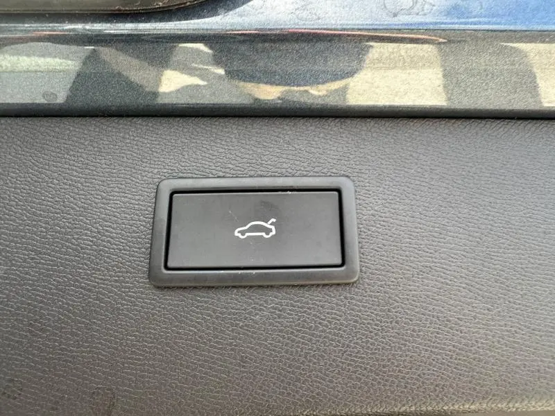 Bouton noir d'ouverture électrique du coffre sur tableau de bord d'une CUPRA Formentor gris Magnétique 2025.