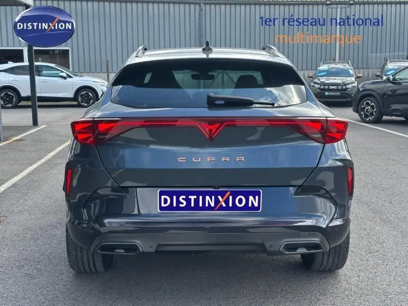 Vue arrière d'une CUPRA Formentor gris magnétique métallisé avec feux LED reliés et double sortie d'échappement.