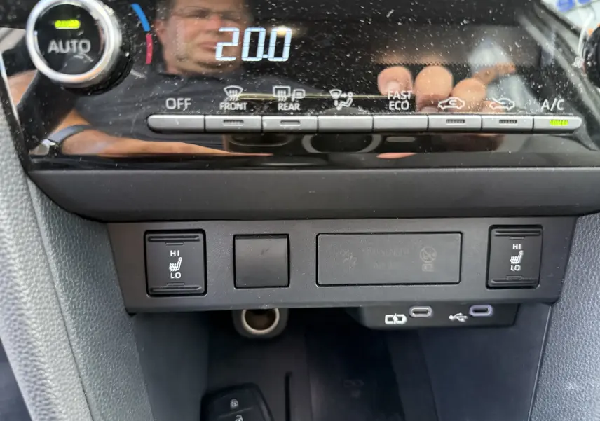 Détail du tableau de bord de la Toyota Yaris Cross 130 CH Design 2024, montrant les commandes de climatisation et sièges chauffants.