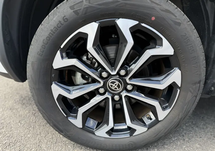 Gros plan sur la jante alliage biton 17 pouces de la Toyota Yaris Cross blanche 2024, avec logo Toyota central.