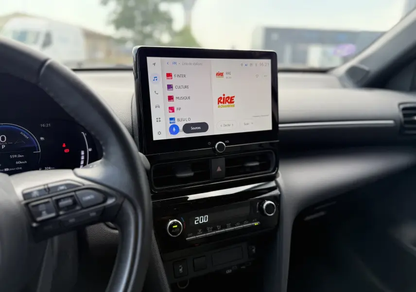 Vue intérieure centrée sur l’écran tactile et le tableau de bord noir de la Toyota Yaris Cross 130 CH Design 2024.