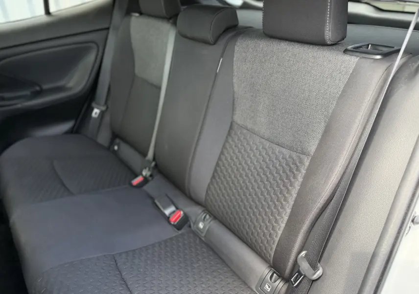 Vue intérieure du siège arrière droit en tissu gris et noir du Toyota Yaris Cross 130 CH Design 2024 hybride essence.