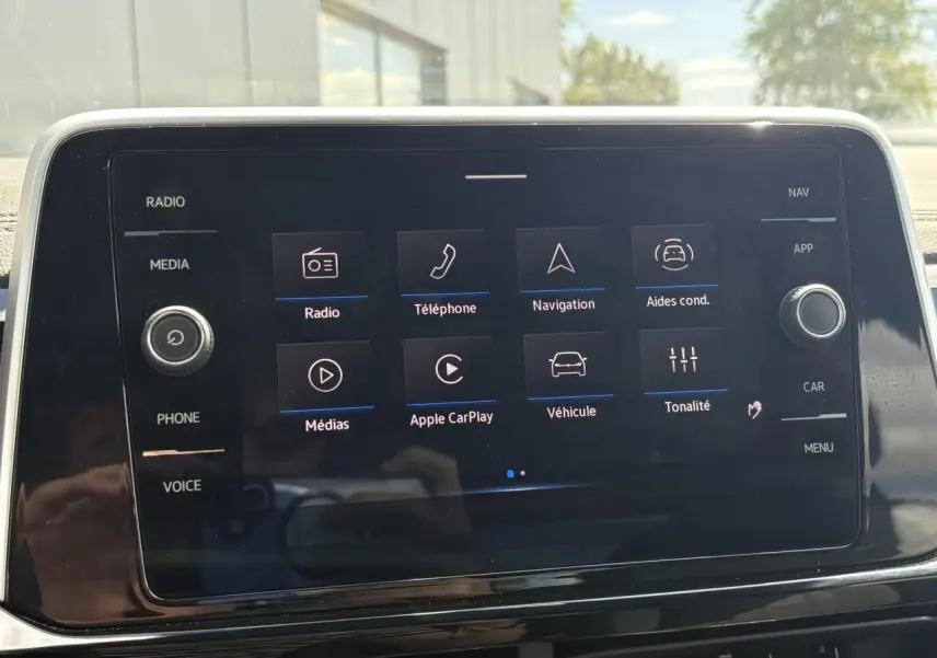 Écran tactile central du Volkswagen T-Roc 2025 affichant les options Apple CarPlay et aides à la conduite.