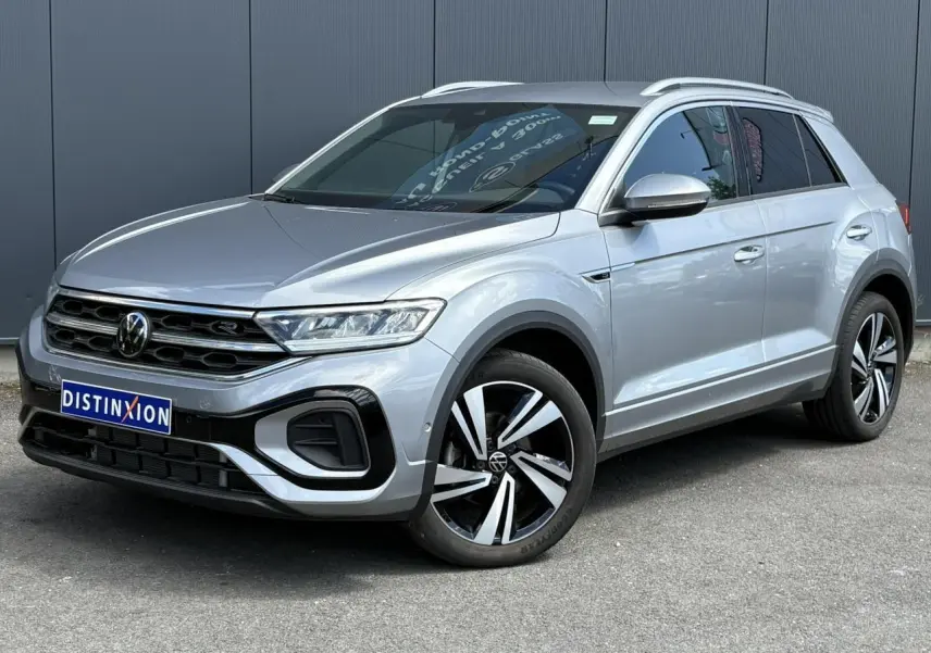 Volkswagen T-Roc 1.5 TSI R-Line gris pyrite en 3/4 avant droit avec jantes alliage 18 pouces Nevada et calandre R-Line.