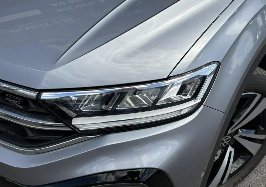 Gros plan sur l'avant droit gris pyrite du Volkswagen T-Roc 2025 avec phares LED et jante alliage R-Line.