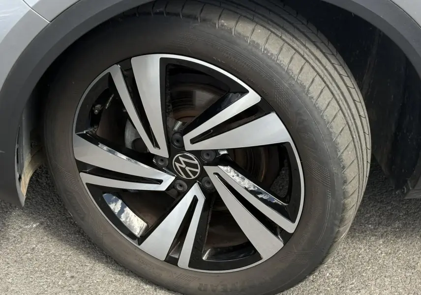 Gros plan sur la jante alliage 18 pouces Nevada bicolore noir et argent du Volkswagen T-Roc gris pyrite.