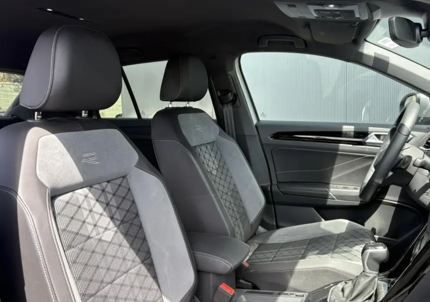 Vue intérieure côté droit du Volkswagen T-Roc 2025, sièges cuir et alcantara gris avec logo R-Line brodé.