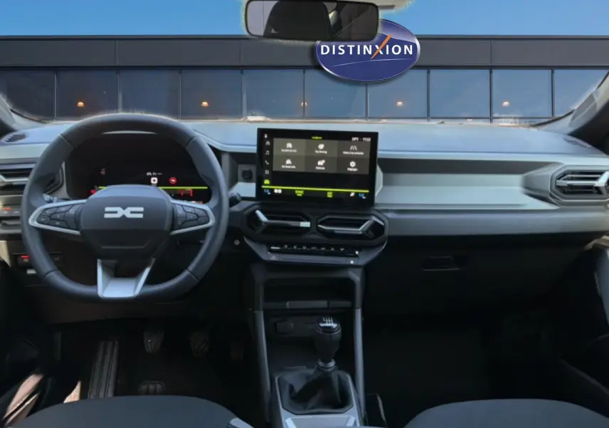 Vue intérieure avant du tableau de bord du Dacia Bigster blanc 2026 avec volant multifonction et écran tactile central.