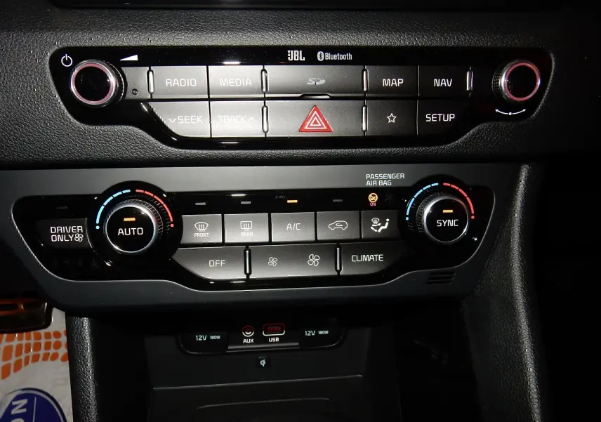 Vue rapprochée du tableau de bord de la Kia Niro hybride 2019, montrant les commandes audio et climatisation.