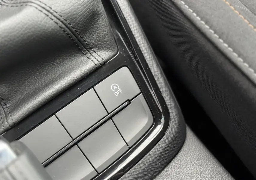 Gros plan sur les boutons de commande près du levier de vitesse en cuir dans la Skoda Scala TSI 110 DSG Ambition 2024.