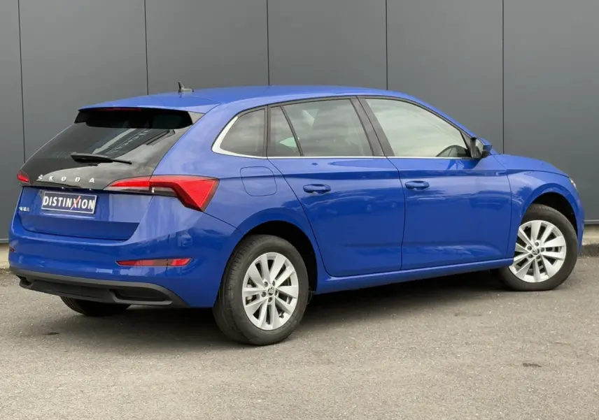 Vue 3/4 arrière droite d'une Skoda Scala 2024 bleu Energy avec jantes alliage argent et toit noir contrasté.