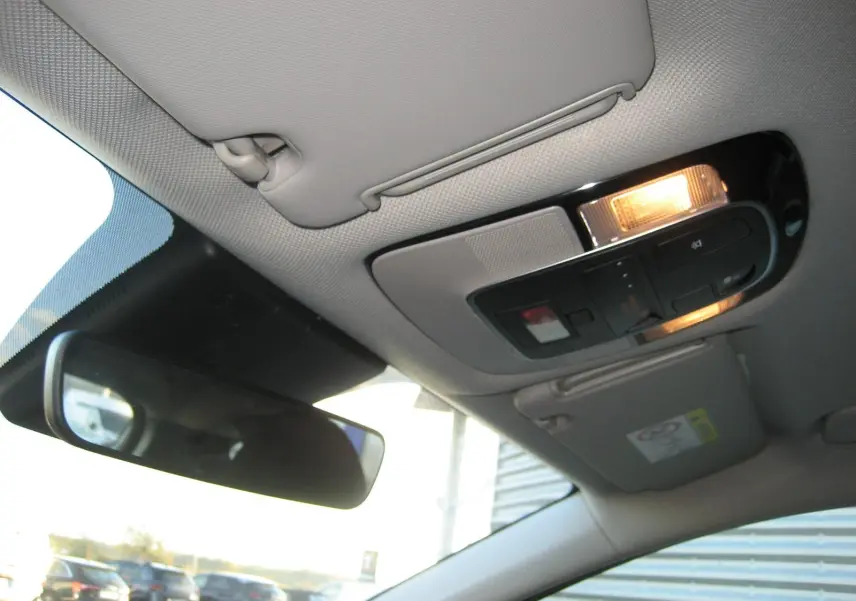 Plafonnier intérieur allumé avec commandes et pare-soleil gris clair dans un Hyundai Tucson noir 2022.