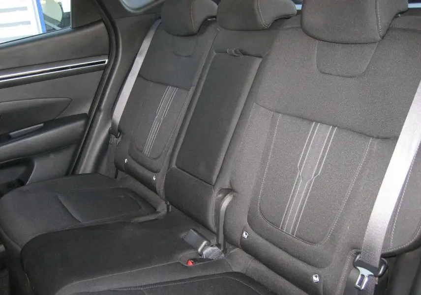 Vue intérieure des sièges arrière noirs du Hyundai Tucson III 2022, avec appuie-têtes et ceintures visibles côté gauche.