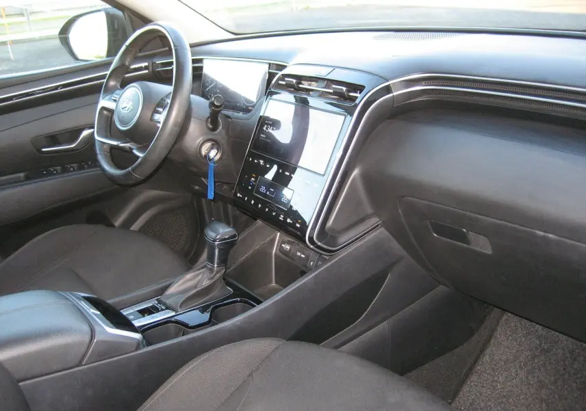 Intérieur noir du Hyundai Tucson 2022, vue côté conducteur sur le tableau de bord et la console centrale avec écran tactile.