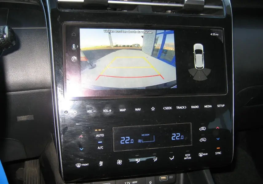Écran tactile central du Hyundai Tucson noir 2022 montrant la caméra de recul et les commandes de climatisation.