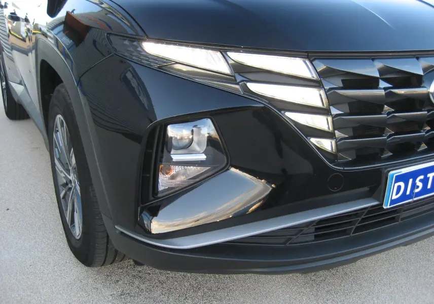 Vue 3/4 avant gauche du Hyundai Tucson noir 2022 mettant en valeur ses phares LED et sa calandre distinctive.