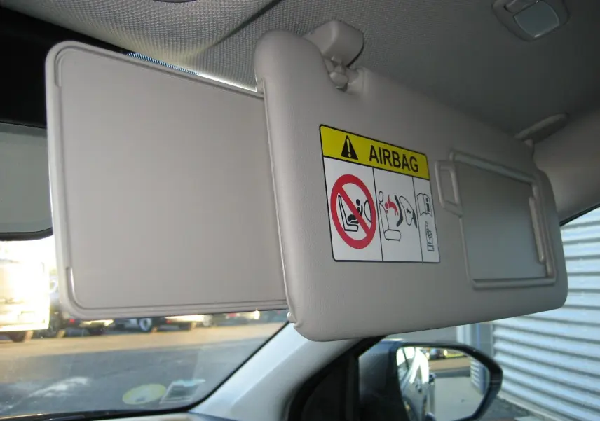 Détail du pare-soleil côté conducteur avec avertissement airbag, intérieur clair du Hyundai Tucson 2022.