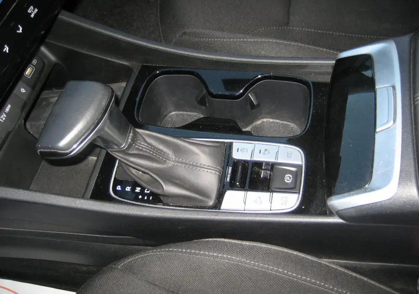 Gros plan sur la console centrale noire du Hyundai Tucson 2022, montrant le levier de vitesses automatique et les commandes adjacentes.