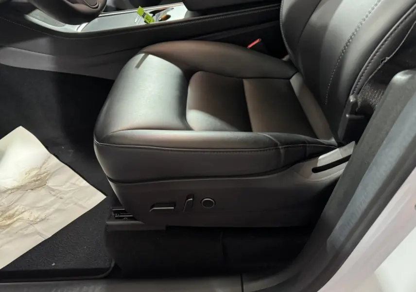 Siège avant droit en cuir noir de la Tesla Model Y blanc, version Grand Autonomie Dual Motor 2022, vue intérieure rapprochée.