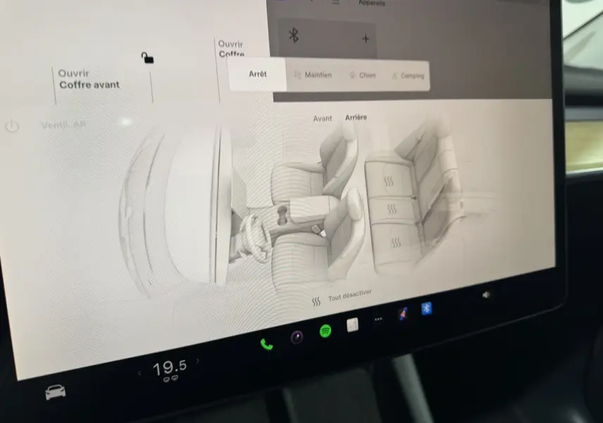 Écran tactile central de la Tesla Model Y blanc 2022 montrant le contrôle des sièges chauffants intérieur