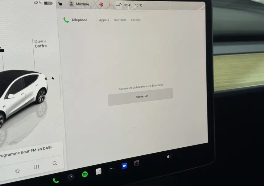 Écran tactile central affichant la connectivité Bluetooth dans l'habitacle d'une Tesla Model Y blanc 2022.