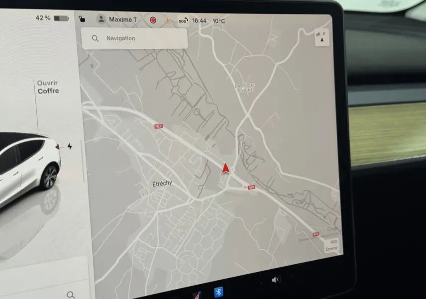 Écran tactile central de navigation affichant une carte et une Tesla Model Y blanche vue de profil côté gauche.