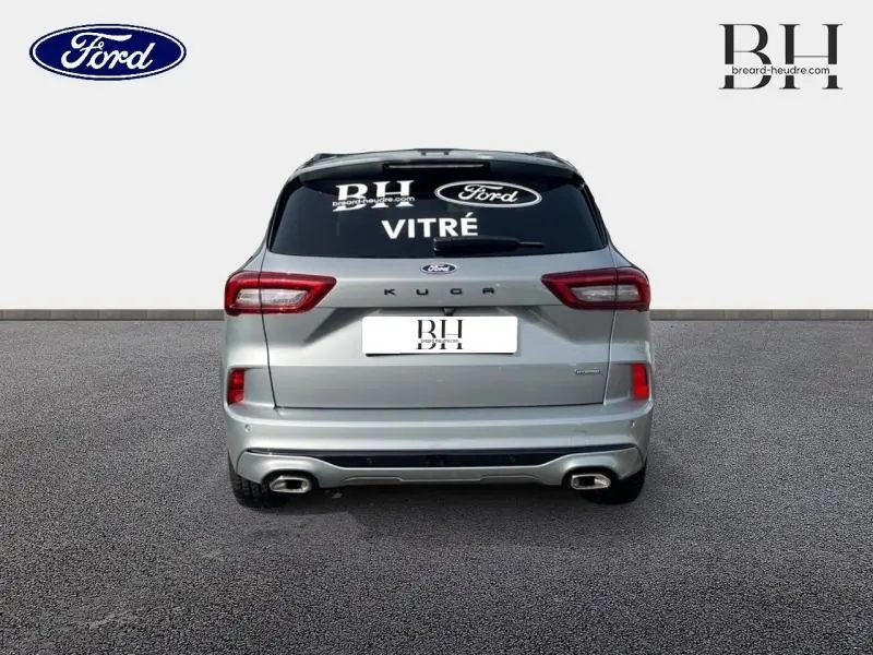 Vue arrière d'un Ford Kuga gris Solar métallisé avec double sortie d'échappement et vitres arrière surteintées.