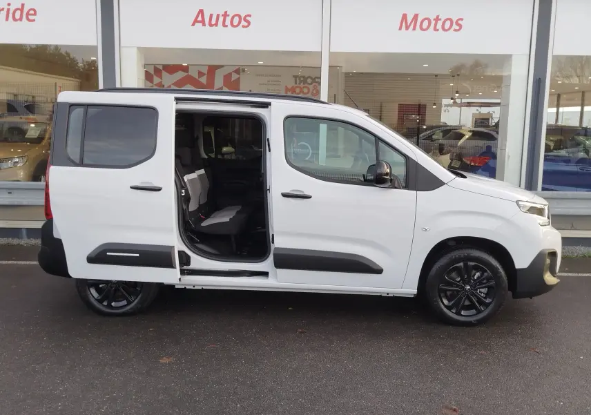 Vue de profil droit d'un Citroën Berlingo Kaolin White 2025 avec porte coulissante arrière ouverte et jantes noires.