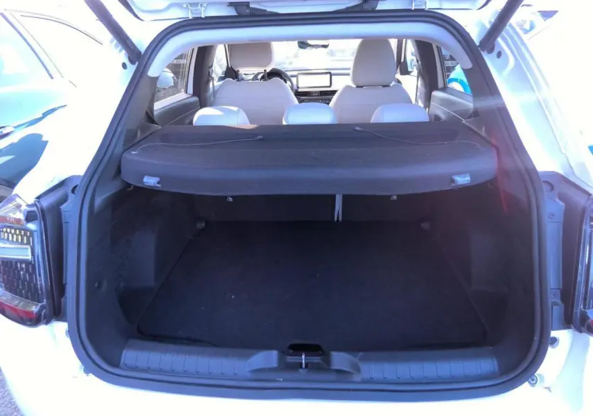 Coffre ouvert vu de l’arrière d’un Fiat 600 blanc 2025, avec cache-bagages et sièges arrière visibles.