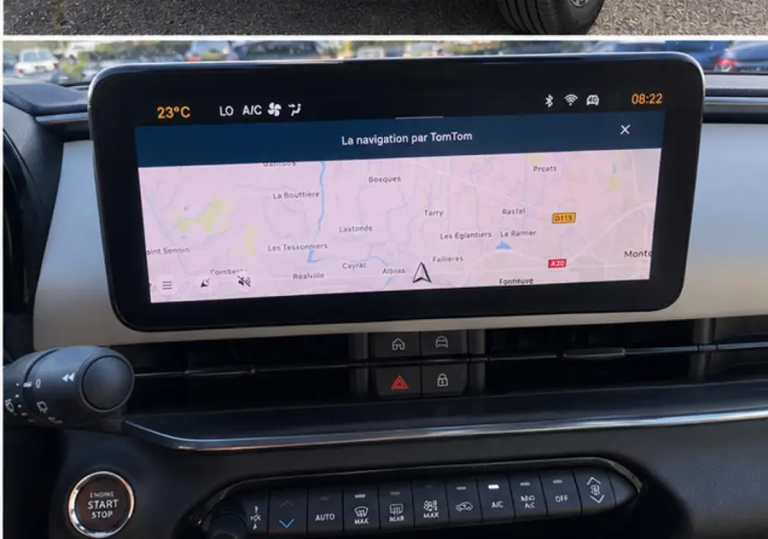 Vue rapprochée de l’écran tactile central et des commandes de la console d’une Fiat 600 blanche hybride 2025.