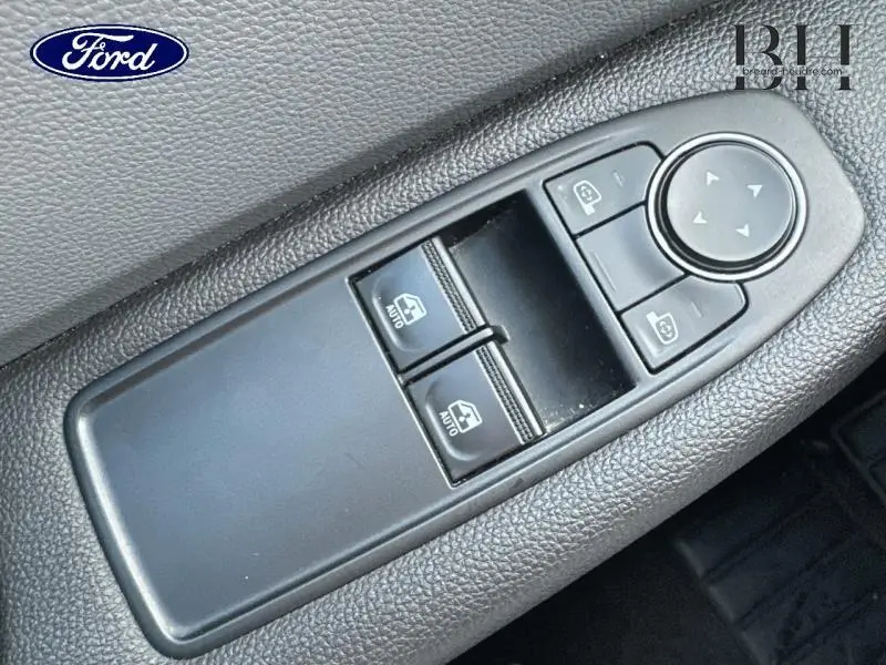 Panneau de commandes des vitres électriques et réglage des rétroviseurs côté conducteur, plastique noir texturé.