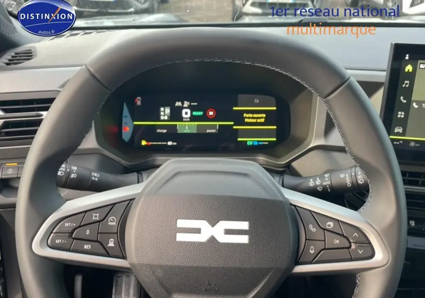 Vue rapprochée du volant en cuir noir du Dacia Bigster gris schiste, avec tableau de bord numérique et commandes intégrées.