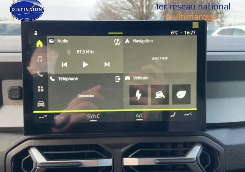 Vue intérieure du tableau de bord du Dacia Bigster 2025 avec écran tactile central affichant les options audio et navigation.