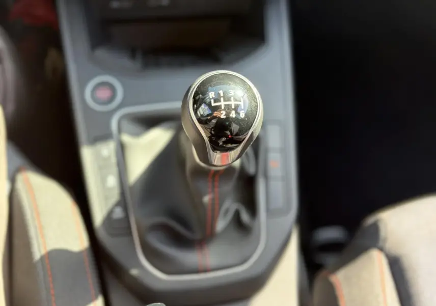 Le levier de vitesses manuel de la SEAT Ibiza TSI 115 FR, vu de dessus avec coutures rouges visibles.