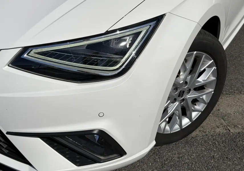 Gros plan sur l'avant droit blanc Candy de la SEAT IBIZA TSI 115 FR, mettant en valeur le phare LED et la jante alliage.