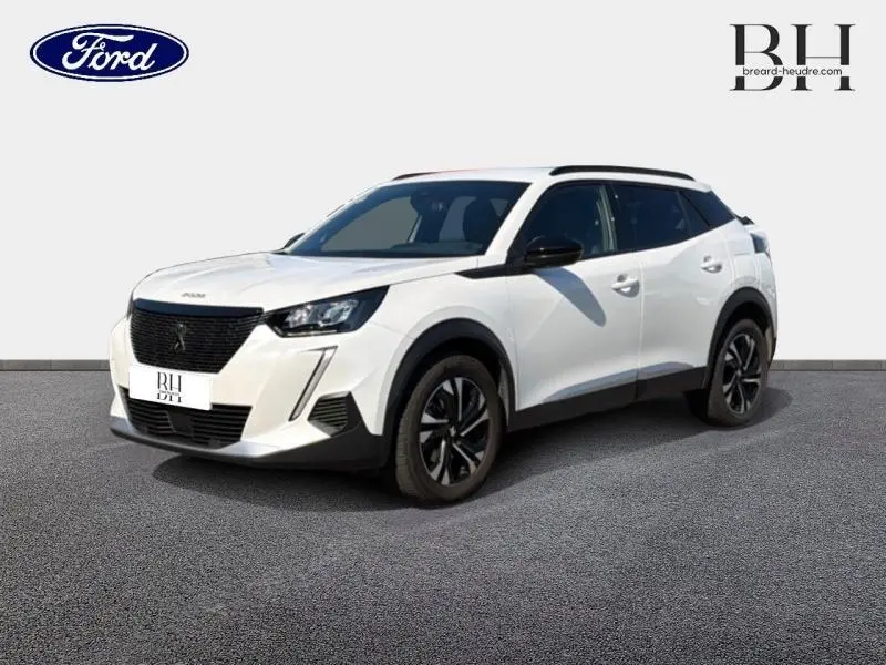 SUV Peugeot 2008 blanc nacré vu en 3/4 avant droit avec jantes alu et barres de toit noires.