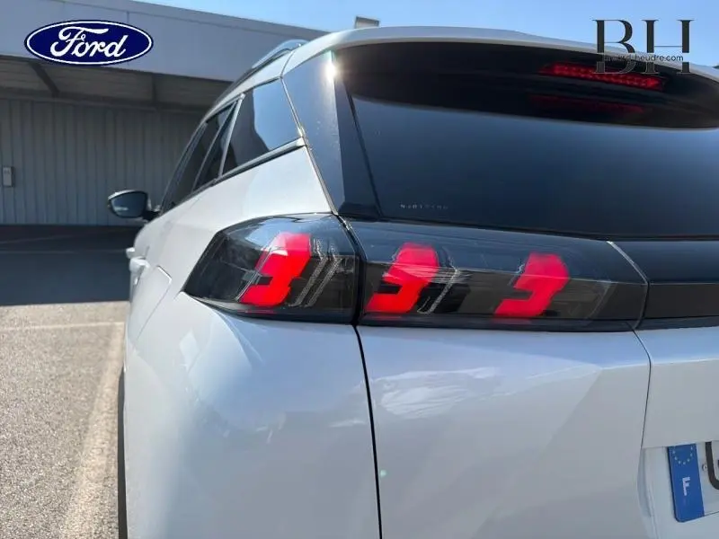 Vue arrière gauche du Peugeot 2008 blanc nacré 2022 mettant en valeur ses feux arrière LED au design tridimensionnel.