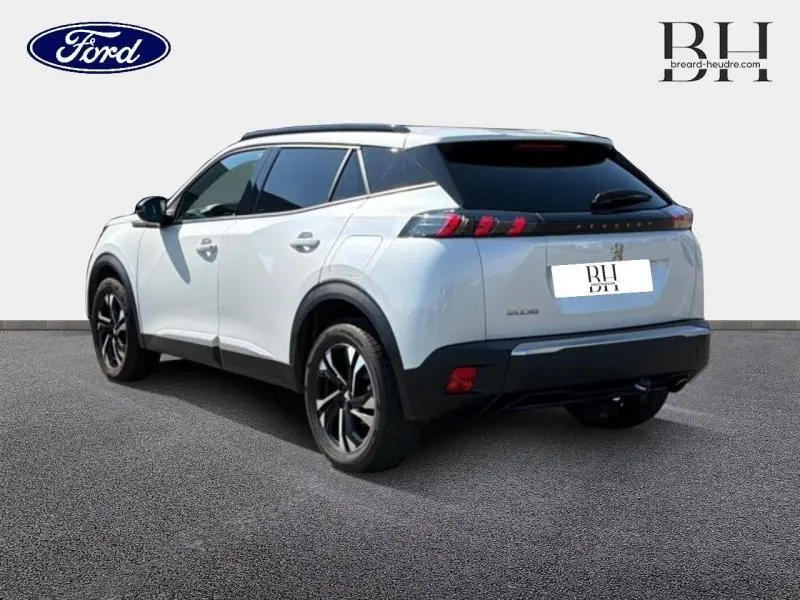 Peugeot 2008 blanc nacré vue 3/4 arrière droit, avec attelage et jantes alliage noires.
