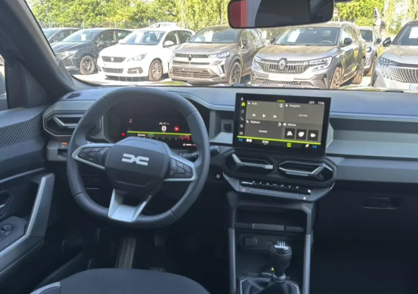 Vue intérieure avant du Dacia Bigster gris schiste, montrant le volant multifonction, l'écran tactile et la boîte manuelle.