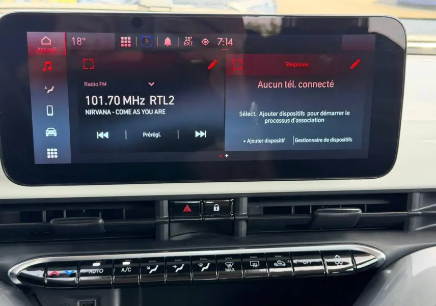 Vue rapprochée de l'écran tactile et de la console centrale de la Fiat 500 e blanche, affichant la radio et les commandes clim.