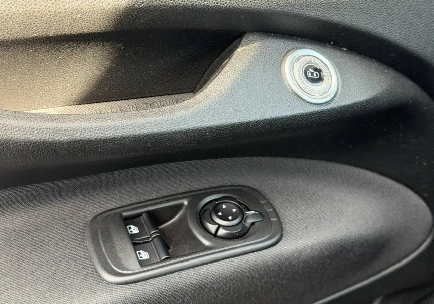 Gros plan sur la commande des vitres électriques et réglage des rétroviseurs côté conducteur de la Fiat 500 e blanche 2023.