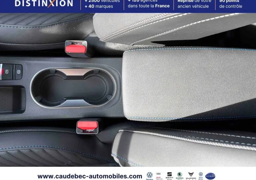Vue plongeante sur la console centrale grise du Renault Symbioz 2026 avec porte-gobelets et coutures bleues contrastantes.